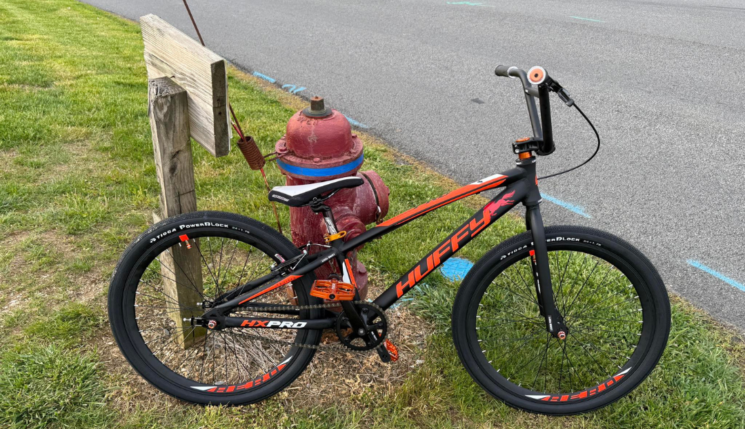 Completed black and orange Huffy HX Pro Cruiser beside a fire hydrant.