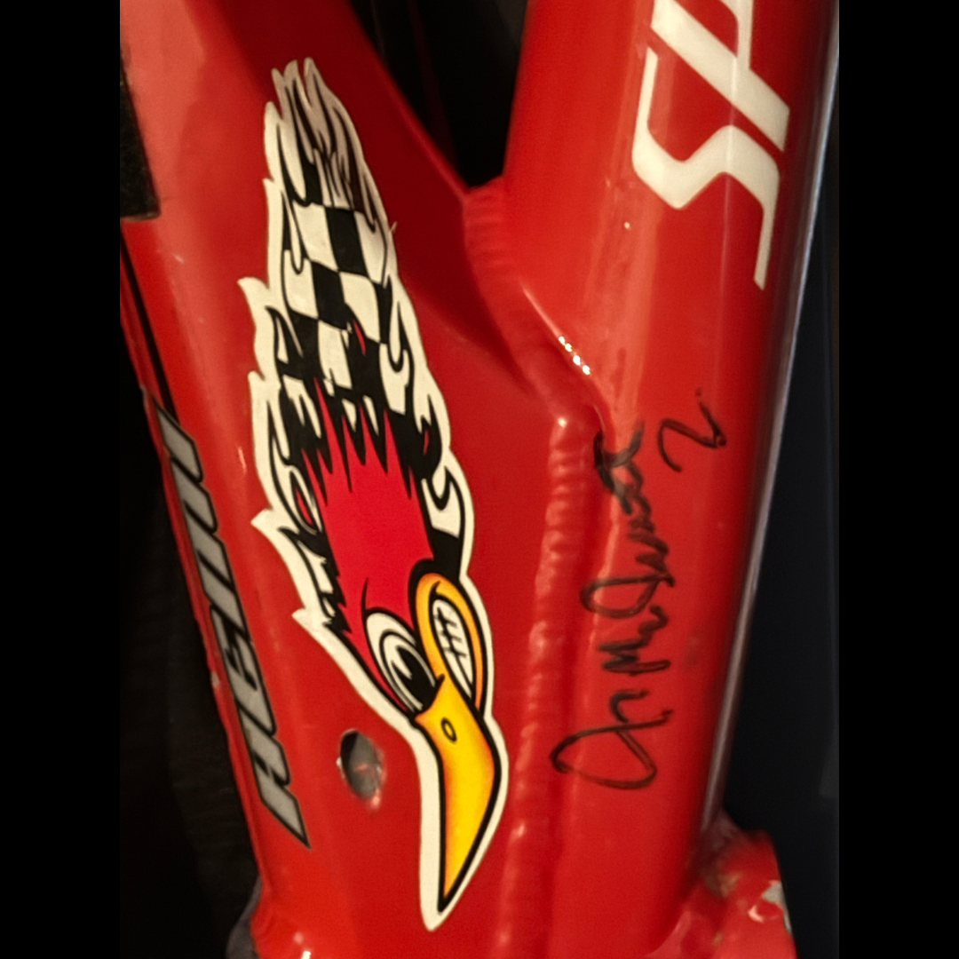 Close-up of a red Specialized frame with a roadrunner graphic and a black marker signature attributed to Jeremy McGrath.