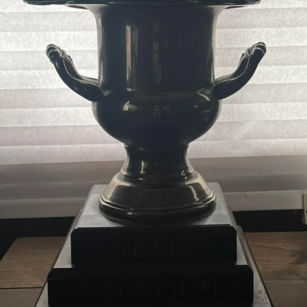 Dark trophy attributed to Harry Leary’s 1994 ABA Vet Pro title, photographed against a bright window.